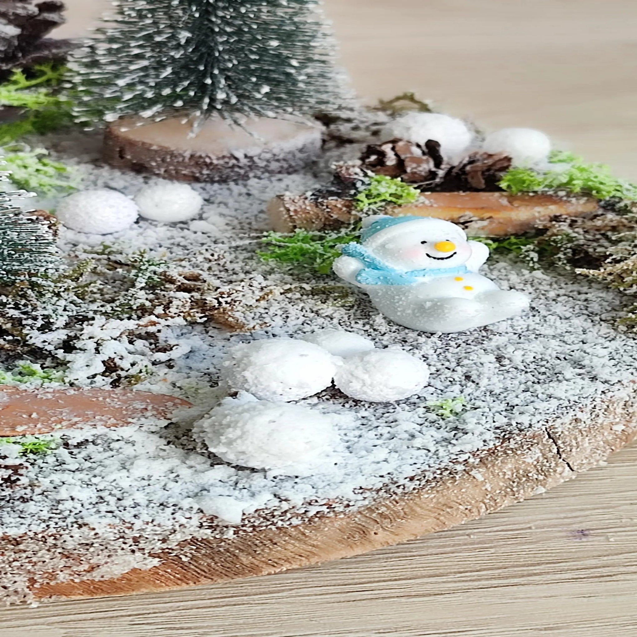 Scène décorative de Noël avec sapins enneigés, bonhomme de neige et décor étoilé – Nos p’tits Bonheurs